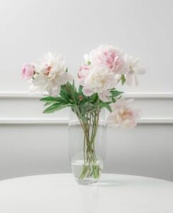 Foto de um vaso de peônias e rosas
