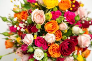 Foto de buquê com diversidade de rosas, contendo as cores laranja e tons diversos de rosa.