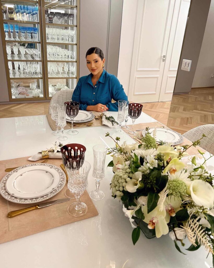 Flores para Decoração encima de uma mesa de jantar com uma pessoa sentada.