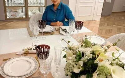 Flores para Decoração encima de uma mesa de jantar com uma pessoa sentada.