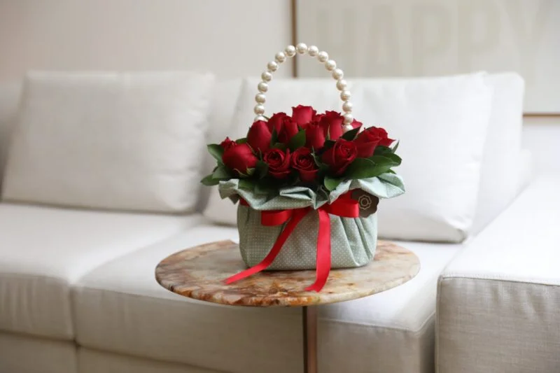 Arranjo de rosas dentro de cesta encima da mesa