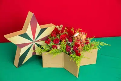 Símbolo da magia natalina: 3 Arranjos de Flores para o Natal 4 Caixa em formato de estrela com buquê de rosas vermelhas dentro que são Símbolo do Natal.