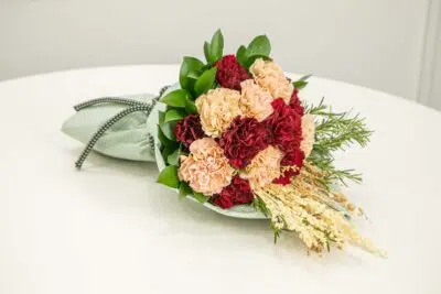 Como presentear com flores de aniversário? 3 buquê de flores com pétalas vermelhas e brancas.