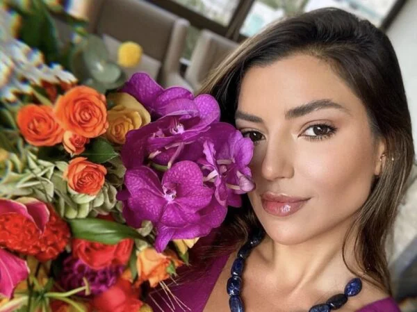 Mulher segurando buquê de flores de janeiro.