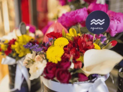 Buquê de flores variadas com placa com o símbolo do signo de aquário.