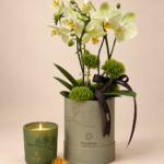 arranjo de orquídeas com vela dourada