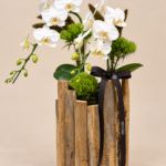 orquídeas brancas em vaso rústico de madeira